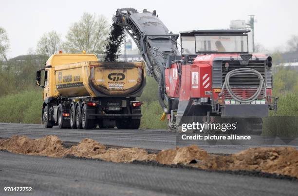 April 2018, Germany, Tribsees: Milling machine at work on the partly sunken baltic sea A20 motorway. 800 metres will be dismantled in total in order...