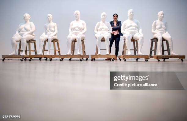 Indian artist Bharti Kher poses behind her work "Six Women" during the exhibition "Facing India", which tackles the feminine perspective on India, at...