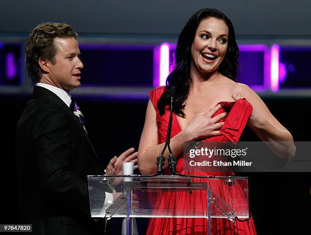 Host Billy Bush looks on as Katherine Heigl accepts the Female Star of the Year Award after part of her dress broke during the ShoWest awards...
