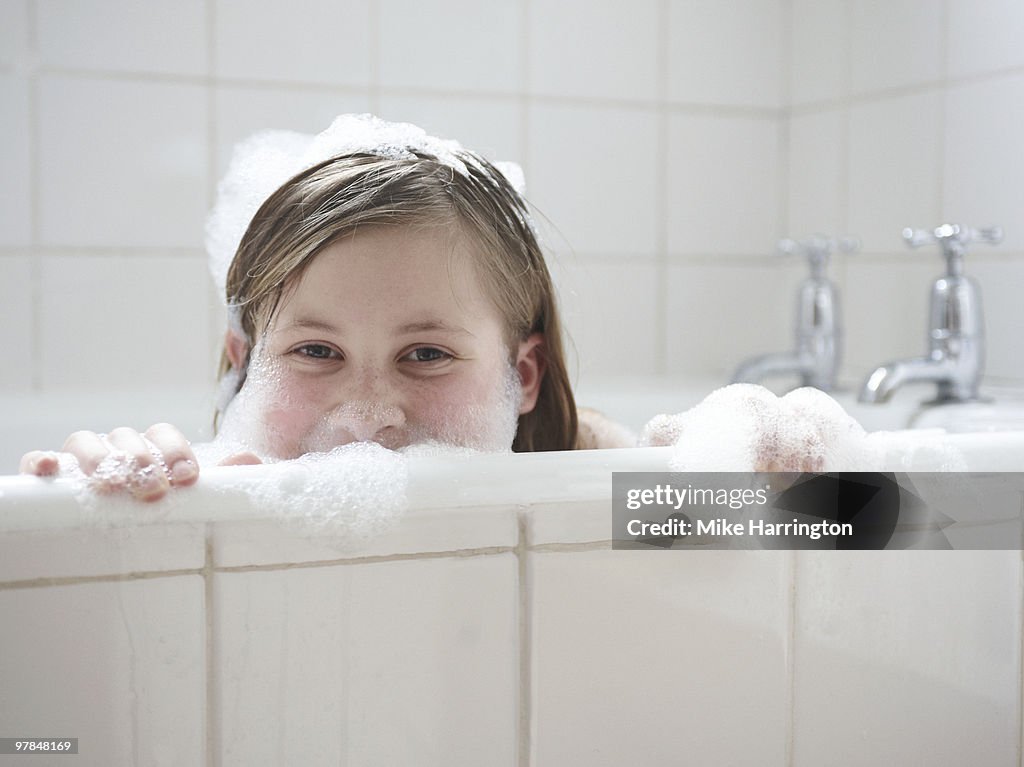 Girl looking over bath tub