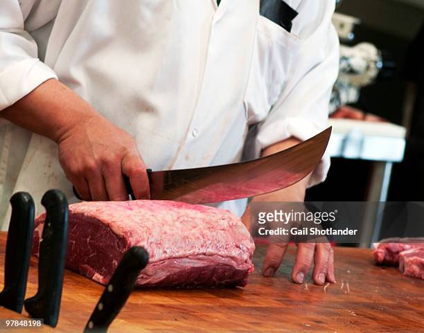 cutting the steaks - butcher knife stock-fotos und bilder