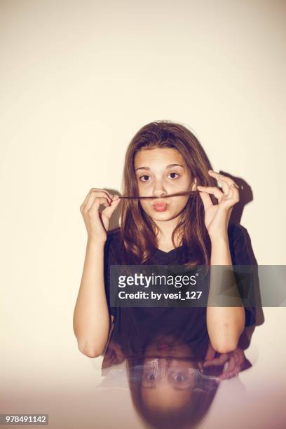 portrait of a young teenage girl making mustache with hair - preteen girl models stock pictures, royalty-free photos & images
