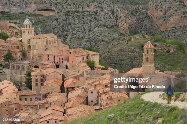 a tourist walks towards albarracin  - teruel province - aragon - spain. - stone town stock pictures, royalty-free photos & images