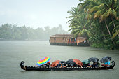 Monsoon time. People crossing a river by boat in rain