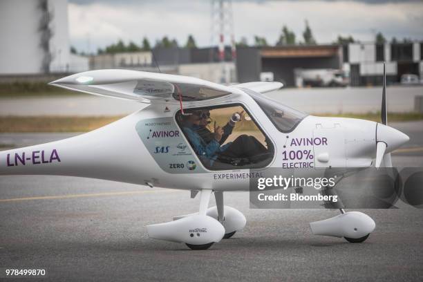 Ketil Solvik-Olsen, Norway's transport minister, left, and Dag Falk-Petersen, chief executive officer of Avinor AS, sit in the cockpit of an Avinor...