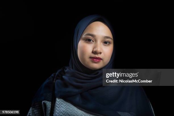 songeur grave portrait de femme musulman avec un fond noir - voile religieux photos et images de collection