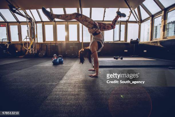 femme athlétique faisant appui renversé dans un club de santé - équilibre sur les mains photos et images de collection