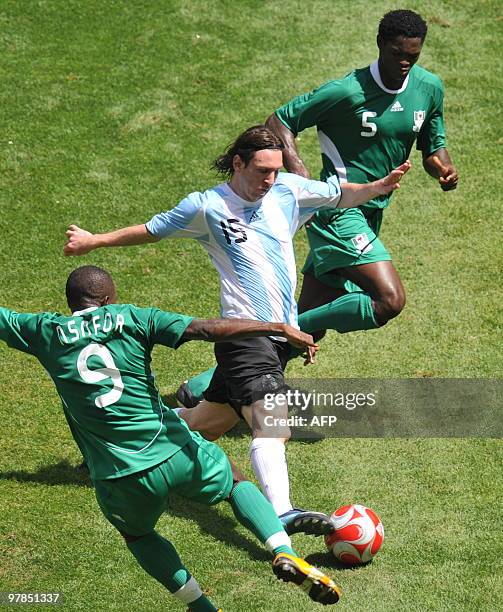 Argentinian forward Lionel Messi is challengeb by Nigerian forward Victor Obinna and defender Dele Adeleye during the men's Olympic football final...