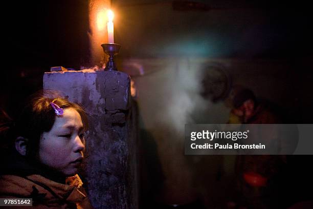 Sainaa sits in a freezing cold house without electricity hiding out from her own family on March 16, 2010 in Ulaan Baatar, Mongolia. Sainaa spends...
