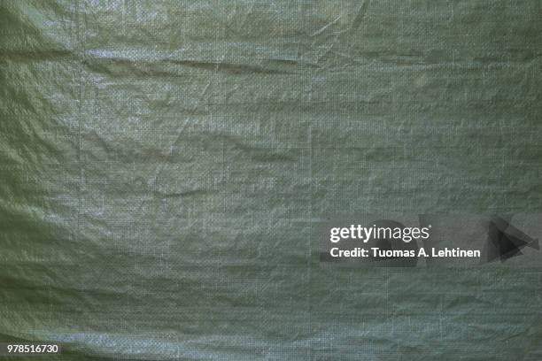 full frame background of a wrinkled green tarp texture - tarpaulin fotografías e imágenes de stock