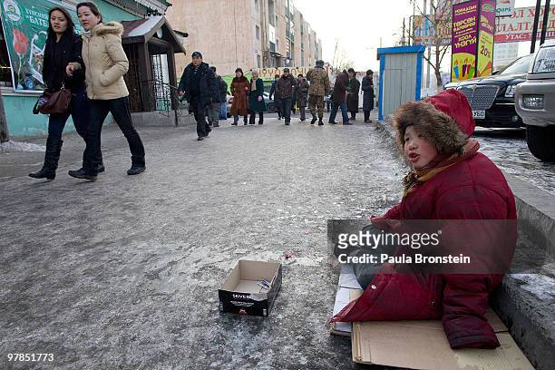 Otgonjargal sits on the icy cold street singing to get some quick cash on March 16, 2010 in Ulaan Baatar, Mongolia. Otgonjargal spends her time on...