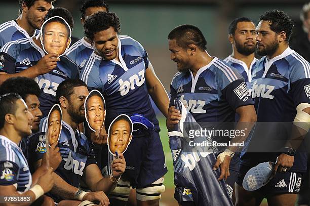 Keven Mealamu of the Blues is surrounded by team mates holding masks after he was presented with a carved wooden gersey for playing his 100th Super...