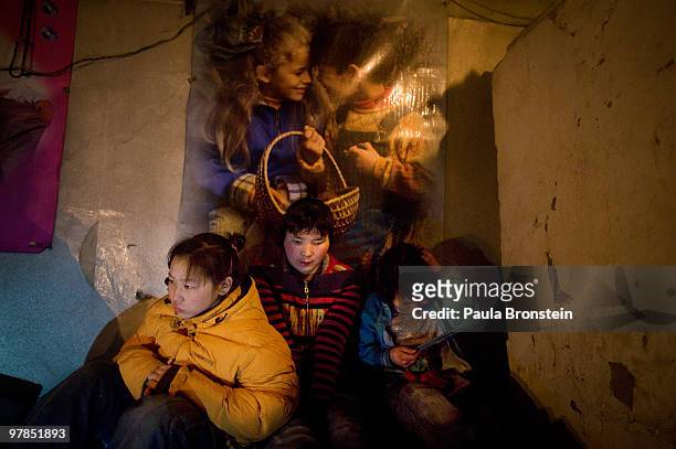 Otgonjargal sister Zulaa and friend Sainaa sit in a freezing cold house without electricity on March 16, 2010 in Ulaan Baatar, Mongolia. They spend...