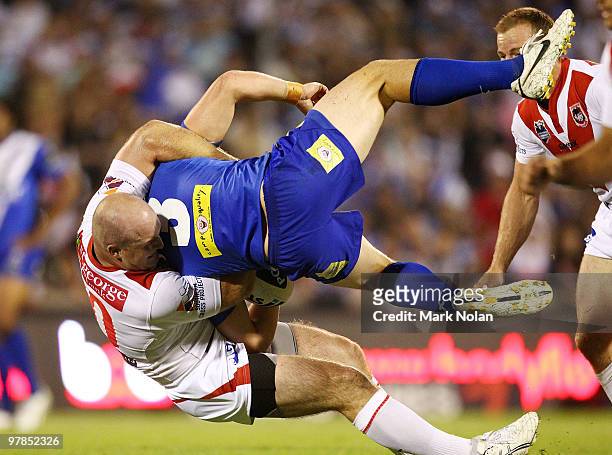 Josh Morris of the bulldogs is tackled by Michael Weyman of the Dragons during the round two NRL match between the St George Illawarra Dragons and...
