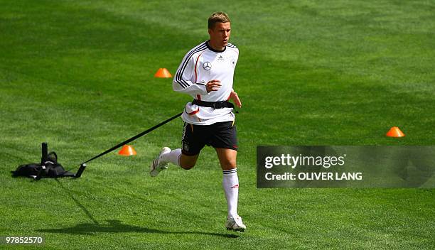 Germany's Lukas Podolski pulls weights during a training session of the national football team at the Stade de Geneve in Geneva 23 May 2006. The...