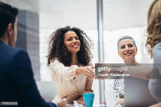 businesswomen shaking hands at the office - african american interview stock pictures, royalty-free photos & images