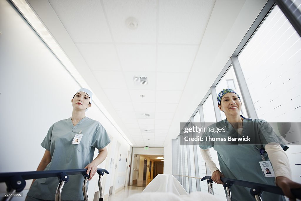 Patient being wheeled by two nurses on gurney