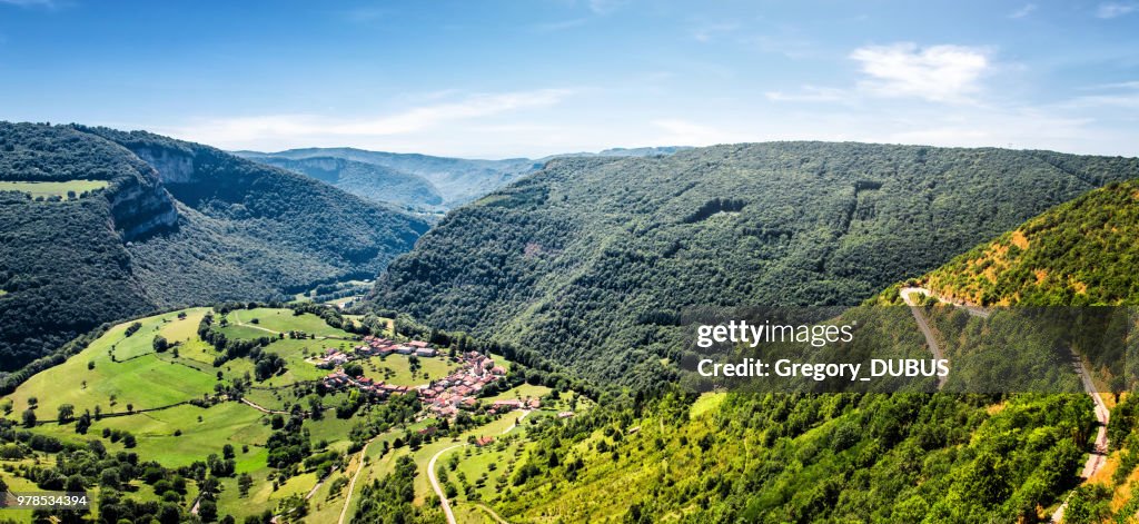 Awesome landscape view of small old French village in circle shape in valley of Bugey mountains in Ain