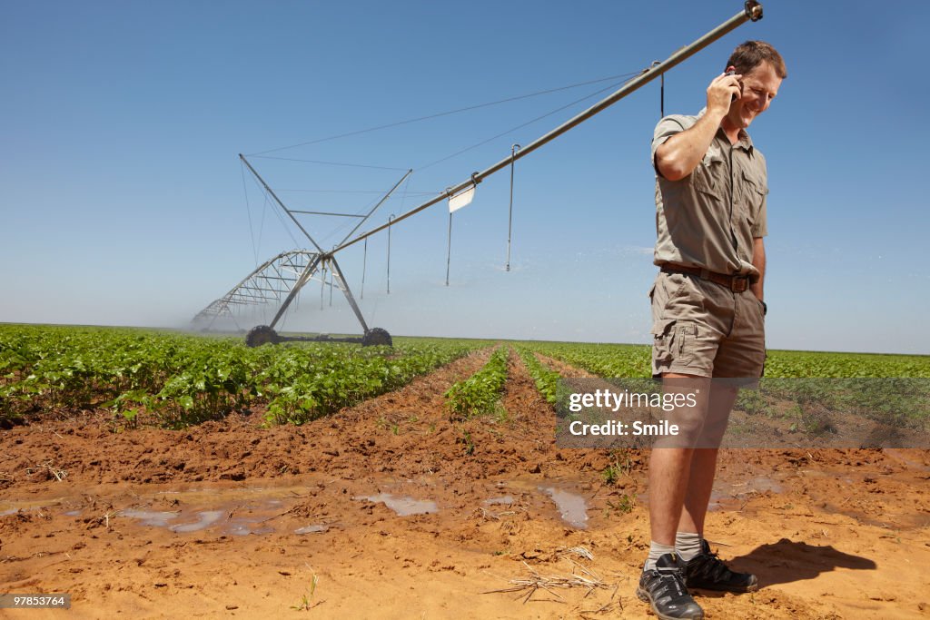 Farmer speaking on cellphone in field