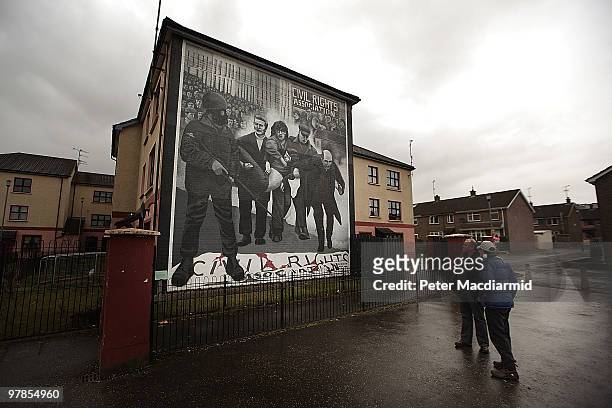 Two men look at a mural remembering the troubles in the Catholic Bogside are of Derry on March 15, 2010 in Northern Ireland. The Bloody Sunday...