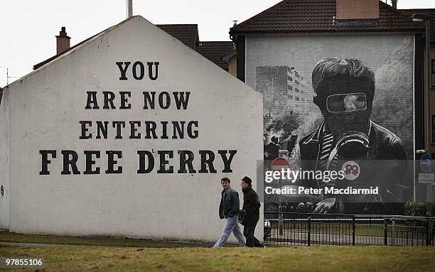 Two residents walk past Free Derry Corner in the Catholic Bogside area of Derry on March 15, 2010 in Northern Ireland. The Bloody Sunday Inquiry...