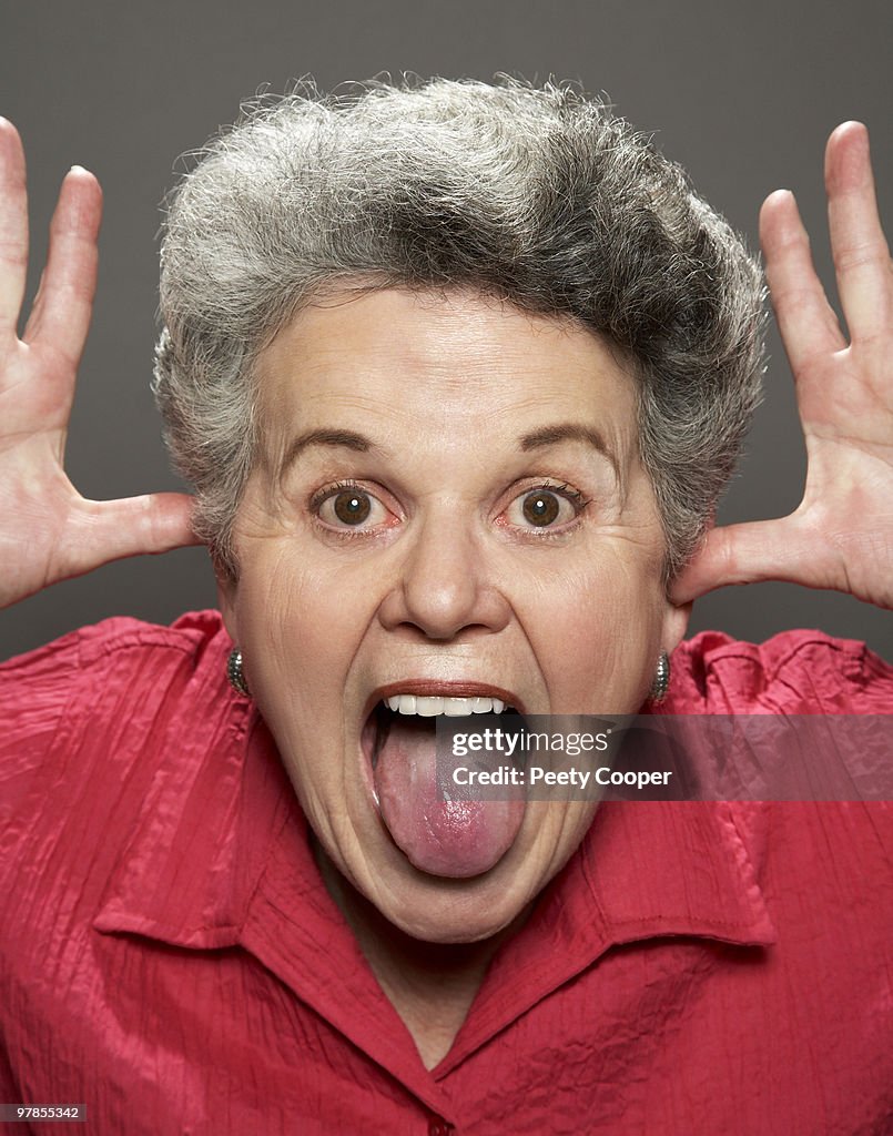 Retired woman making funny face at camera