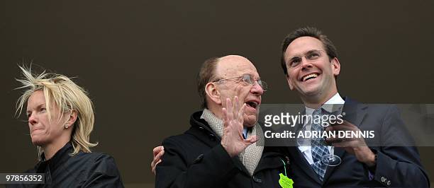 Media mogul Rupert Murdoch stands beside his son James Murdoch and daughter Elisabeth Murdoch on a balcony overlooking the racing during the third...