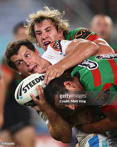 Greg Bird of the Titans is tackled heavily by Dave Tyrell and John Sutton of the Rabbitohs during the round two NRL match between the South Sydney...