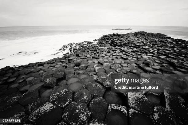 rock formation surrounded by water, giants causeway, ireland - fulford stock pictures, royalty-free photos & images