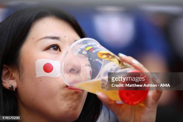 Female fan of Japan looks on with a beer prior to the 2018 FIFA World Cup Russia group H match between Colombia and Japan at Mordovia Arena on June...
