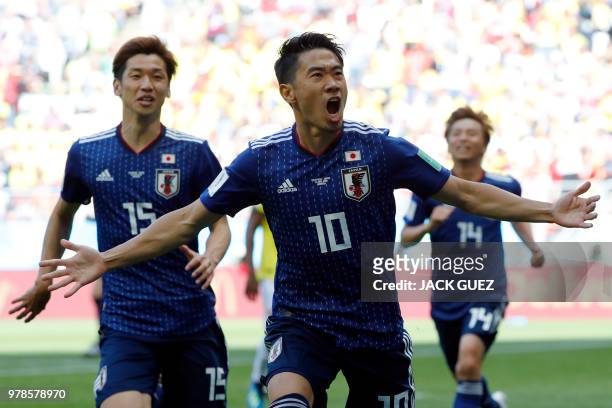 Japan's midfielder Shinji Kagawa celebrates with teammates after scoring a penalty during the Russia 2018 World Cup Group H football match between...