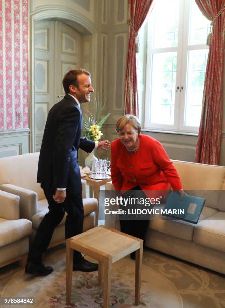 German Chancellor Angela Merkel and French President Emmanuel Macron take their seats prior to their bilateral talks on June 19 at the Meseberg...
