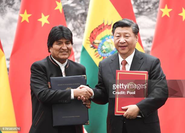 Bolivia's President Evo Morales shakes hands with Chinese President Xi Jinping during a signing ceremony at the Great Hall of the People on June 19,...