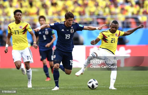 Hiroki Sakai of Japan is tackled by Jose Izquierdo of Colombia and Johan Mojica of Colombia during the 2018 FIFA World Cup Russia group H match...