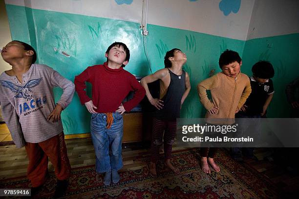 Mongolian street children excercise at a child detention center March 11, 2010 in Ulaan Baatar, Mongolia. The police picked up a dozen boys to get...