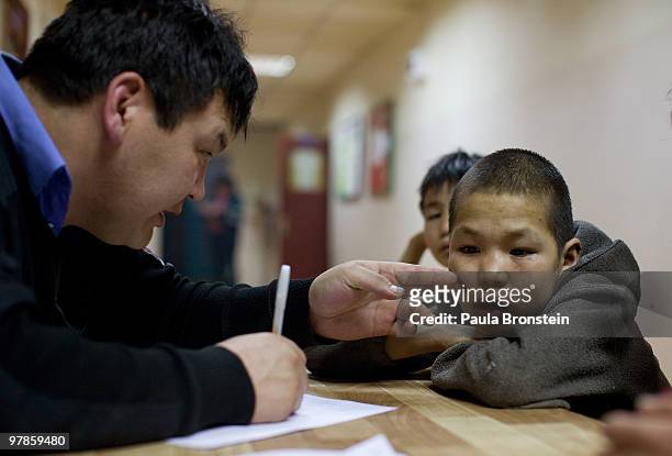 Mongolian police gets the attention of a boy while he is registered at a child detention center March 11, 2010 in Ulaan Baatar, Mongolia. The police...