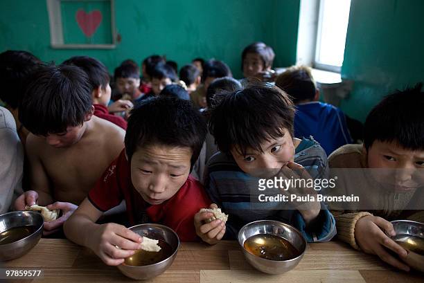 Mongolian street children eat a midday snack of tea and bread at a child detention center March 11, 2010 in Ulaan Baatar, Mongolia. The police picked...