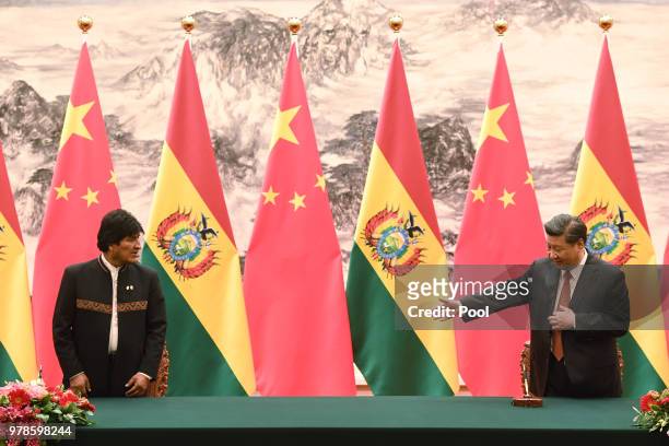Chinese President Xi Jinping gestures to Bolivia's President Evo Morales as they arrive for a signing ceremony at the Great Hall of the People on...
