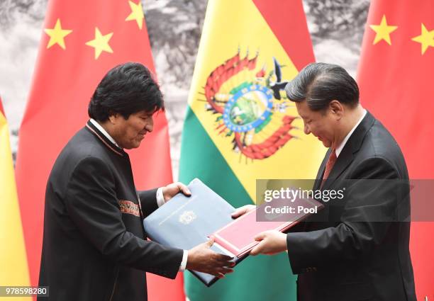 Bolivia's President Evo Morales exchanges documents with Chinese President Xi Jinping during a signing ceremony at the Great Hall of the People on...