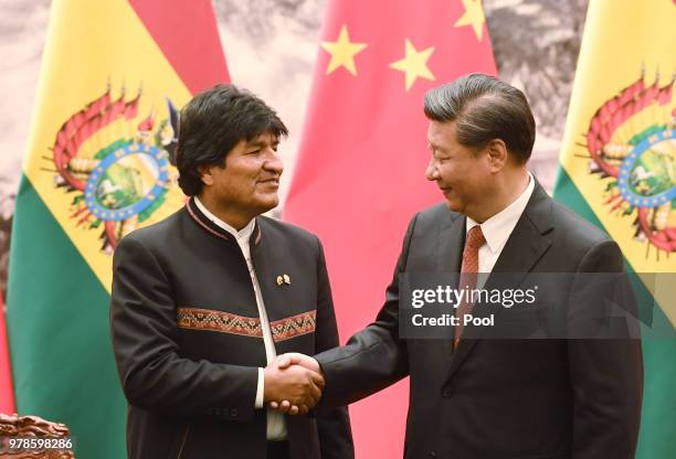 Bolivia's President Evo Morales shakes hands with Chinese President Xi Jinping during a signing ceremony at the Great Hall of the People on June 19,...