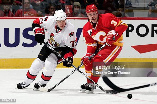Ian White of the Calgary Flames skates against Jarkko Ruutu of the Ottawa Senators on March 11, 2010 at Pengrowth Saddledome in Calgary, Alberta,...