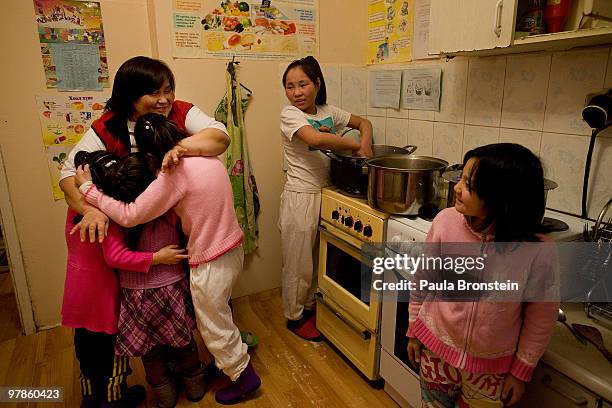 At the Lighthouse girls shelter Mongolian girls get a hug from the caretaker while dinner is prepared in the kitchen March 10, 2010 in Ulaan Baatar,...