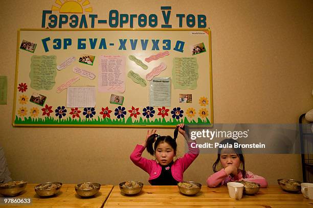 At the Lighthouse girls shelter girls wait for everyone to sit down for dinner March 10, 2010 in Ulaan Baatar, Mongolia. The police picked up a dozen...