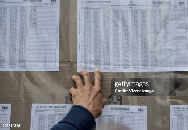 Man checks for his name at a polling station during the presidential ballotage between Conservative Ivan Duque and leftist Gustavo Petro on June 17,...