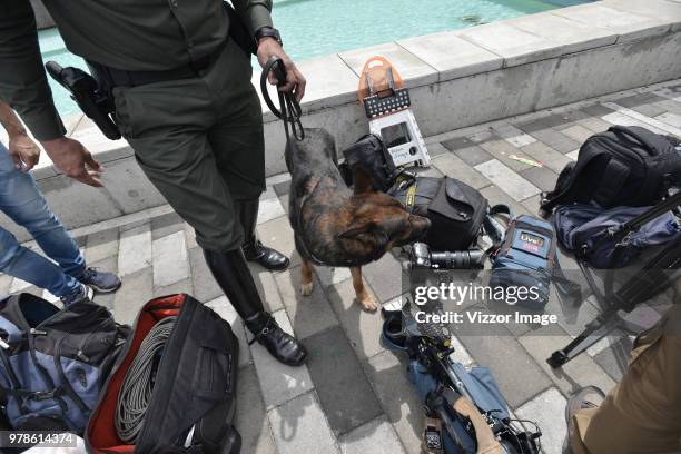 Police officer with a service dog check the press gear at headquarters of Ivan Duque, presidential candidate for the Centro Democratico party, during...