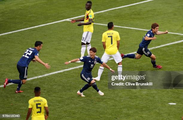 Yuya Osako of Japan celebrates with teammates after scoring his team's second goal as Davinson Sanchez of Colombia looks dejected during the 2018...