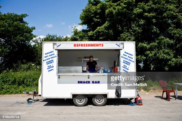 Young female cook reads a newspaper at a roadside burger van on 16th June 2008 in West Basingstoke in the United Kingdom.