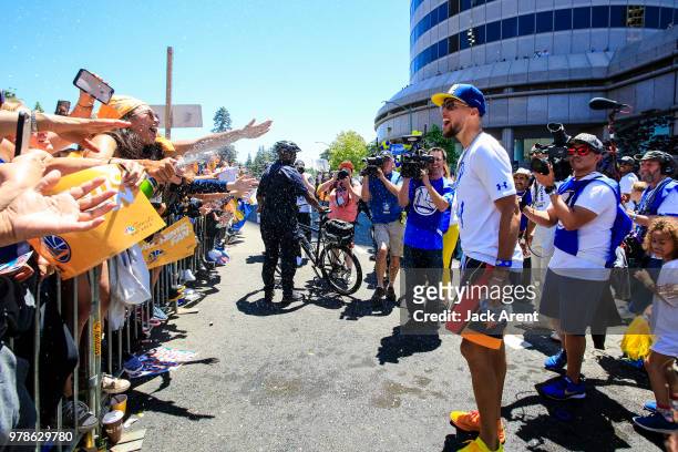 Stephen Curry of the Golden State Warriors interacts with fans during the Victory Parade on June 12, 2018 in Oakland, California. The Golden State...