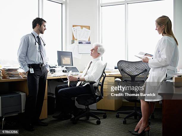 three doctors in discussion in medical office - leanintogether stock pictures, royalty-free photos & images