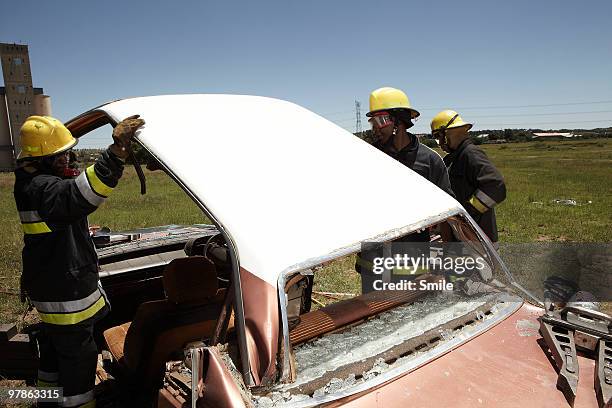 Firemen cutting the roof off a car